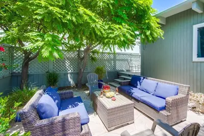 a patio with a blue couch and chairs and a table at Endless Summer 1 in San Diego