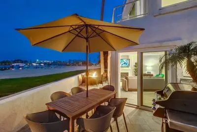 a wooden table and chairs with an umbrella at Jamaica Sands WINTER SPECIAL! in San Diego