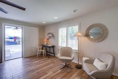 a living room with a table and chairs and a mirror at Kennebeck Cove in San Diego
