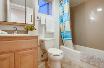 a bathroom with a toilet and a tub and a sink at Kennebeck Cove in San Diego