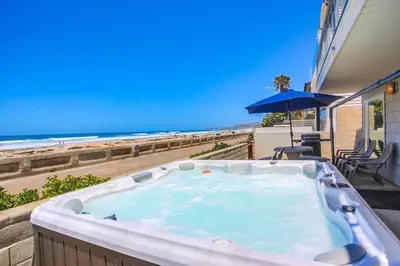 a hot tub on a patio with the beach at Life's A Beach 1 in San Diego