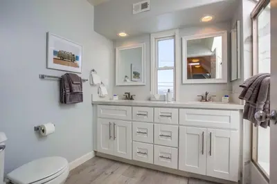 a white bathroom with a toilet and a sink at Life's A Beach 1 in San Diego