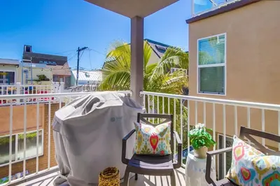 a balcony with a chair and a palm tree at Palms Paradise 1 in San Diego