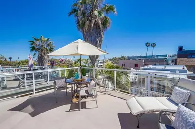 a patio with a table and an umbrella on a balcony at Palms Paradise 1 in San Diego