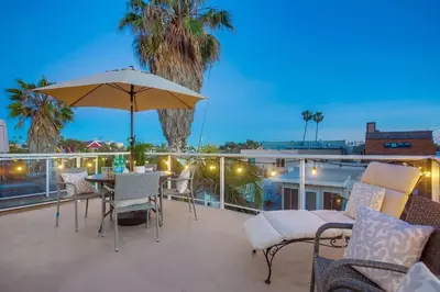 a patio with a table and chairs and an umbrella at Palms Paradise 1 in San Diego