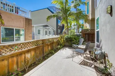 a patio with a table and chairs in front of a house at Palms Paradise 1 in San Diego