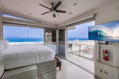 a bedroom with a bed and a view of the beach at Surf Style 1 in San Diego