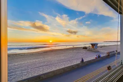 a view of the beach at sunset from a balcony at Surf Style 2 in San Diego