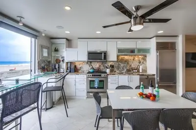 a kitchen with a table with a bowl of fruit on it at Surf Style 2 in San Diego