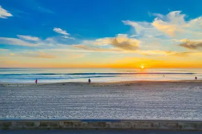 a group of people walking on the beach at sunset at Surf Style 2 in San Diego