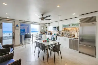 a kitchen with a table and chairs and a kitchen with the ocean at Surf Style 2 in San Diego