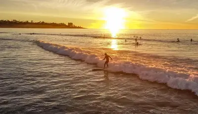 a person riding a wave on a surfboard in the ocean at The Shores 2 in San Diego