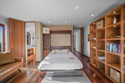 a bedroom with a bed and a book shelf at Stunning Ocean-View Villa, Walking to La Jolla Cove in San Diego
