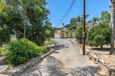 a road with trees and a house in the distance at Designer Poolside 1Bed1Bth Retreat in La Mesa