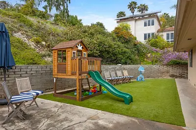 a playground with a slide and chairs on the grass at Designer Poolside 1Bed1Bth Retreat in La Mesa