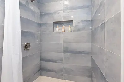 a bathroom with a shower with gray tiles at Designer Poolside 1Bed1Bth Retreat in La Mesa