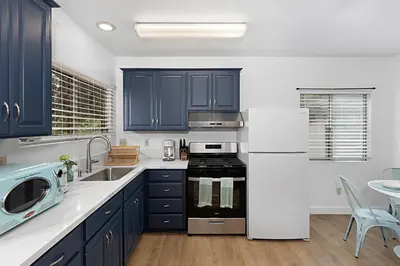 a kitchen with blue cabinets and a sink and a stove at Designer Poolside 1Bed1Bth Retreat in La Mesa