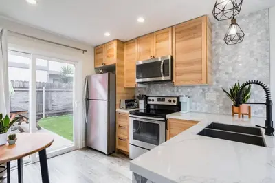 a kitchen with wooden cabinets and a stainless steel refrigerator at Casa Nova - Central San Diego FREE parking in San Diego