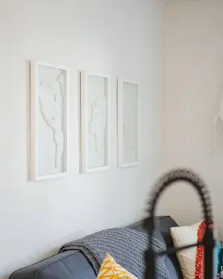three framed pictures on a white wall with a chair at Casa Nova - Central San Diego FREE parking in San Diego