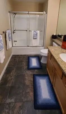 a bathroom with a shower and a toilet and blue mats at 28 NIGHT MINIMUM in the Gaslamp Quarter by Petco Park, pool, jacuzzi, dogs ok in San Diego