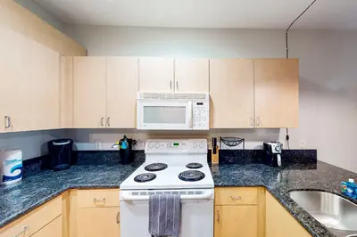 a kitchen with a white stove and a microwave at San Diego's Diamond in San Diego
