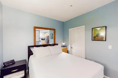 a bedroom with a white bed and a mirror at San Diego's Diamond in San Diego
