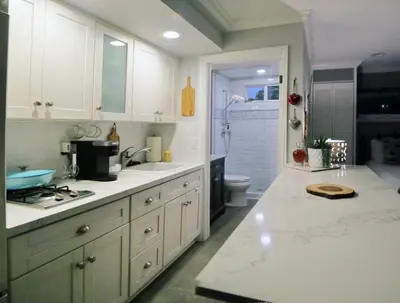 a kitchen with white cabinets and a sink and a shower at Cottage On The Greens - Studio in Poway