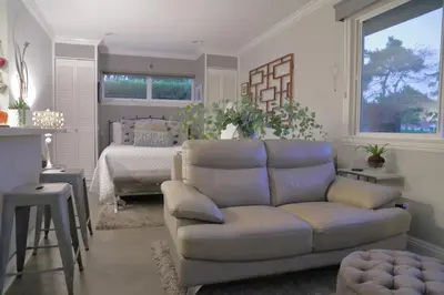 a living room with a couch and a bed at Cottage On The Greens - Studio in Poway