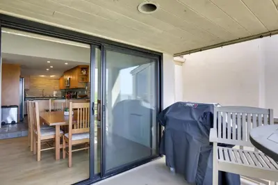 a sliding glass door in a room with a table and chairs at Solana Beach Condo with Community Pool, Beach Access in Solana Beach