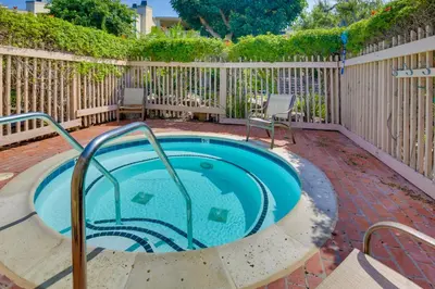 a swimming pool in a backyard with a wooden fence at Solana Beach Condo with Community Pool, Beach Access in Solana Beach
