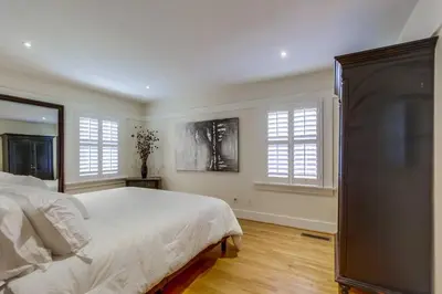 a bedroom with a white bed and two windows at Cozy Craftsman Bungalow, Hillcrest/Mission Hills in San Diego