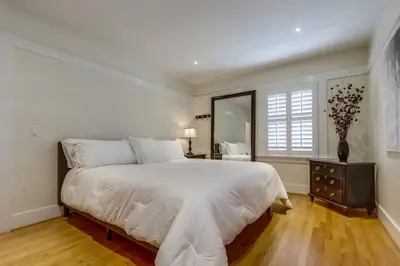 a white bedroom with a large bed and a window at Cozy Craftsman Bungalow, Hillcrest/Mission Hills in San Diego