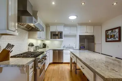a kitchen with white cabinets and a stove top oven at Cozy Craftsman Bungalow, Hillcrest/Mission Hills in San Diego