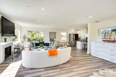 a living room with a white couch and a kitchen at Laguna Beach Escape with Hot Tub and Ocean Views! in Laguna Beach