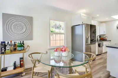 a kitchen with a glass table with chairs and a refrigerator at Laguna Beach Escape with Hot Tub and Ocean Views! in Laguna Beach