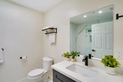 a bathroom with a sink and a toilet and a mirror at Laguna Beach Escape with Hot Tub and Ocean Views! in Laguna Beach