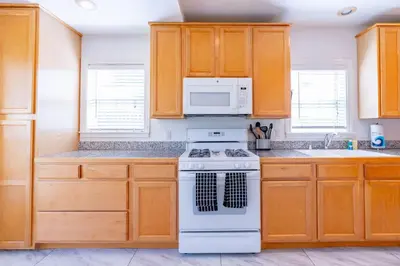 a kitchen with wooden cabinets and a white stove top oven at North Park Sanctuary in San Diego