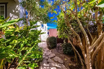 a garden with a stone walkway next to a house at North Park Sanctuary in San Diego