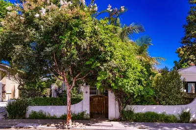 a tree in front of a house with a wooden gate at North Park Sanctuary in San Diego