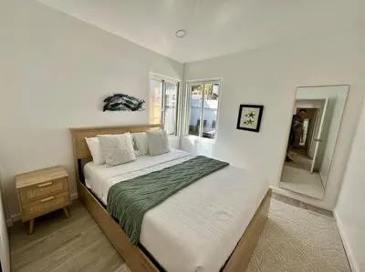 a bedroom with a large bed and a mirror at Beachside 2BR close 2 sand, town in Laguna Beach