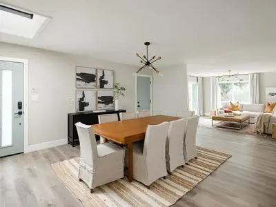 a dining room with a wooden table and white chairs at Peaceful 4br with Fire Pit and Huge Yard in San Diego