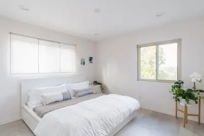 a white bedroom with a bed and two windows at Spacious and Bright 5-Bedroom Oasis Pool and Yard in La Mesa