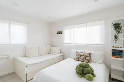 a white bedroom with a turtle pillow on a bed at Spacious and Bright 5-Bedroom Oasis Pool and Yard in La Mesa