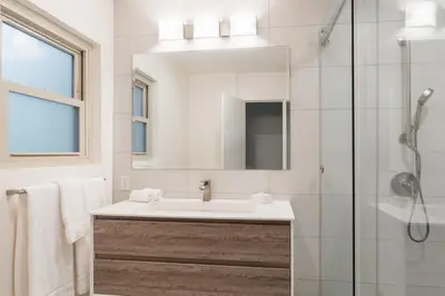 a white bathroom with a sink and a shower at Spacious and Bright 5-Bedroom Oasis Pool and Yard in La Mesa