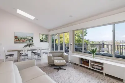 a living room with white furniture and large windows at Spacious and Bright 5-Bedroom Oasis Pool and Yard in La Mesa