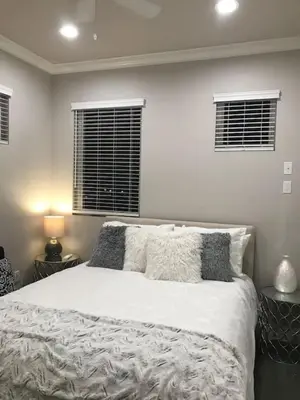 a bedroom with a large white bed with two windows at 4048 Stylish condo in Hillcrest Mission Hills in San Diego