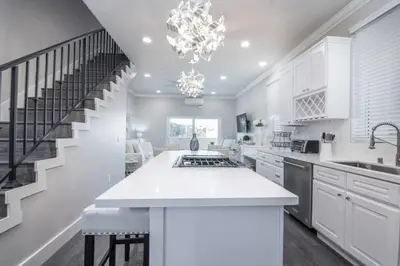 a kitchen with white cabinets and a staircase at 4048 Stylish condo in Hillcrest Mission Hills in San Diego