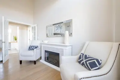 a living room with a fireplace and a white chair at 4221 Urban oasis in Hillcrest Mission Hills in San Diego