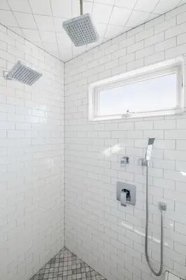 a white tiled bathroom with a shower and a window at 4221 Urban oasis in Hillcrest Mission Hills in San Diego