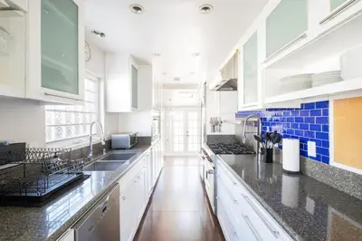 a kitchen with white cabinets and black counter tops at 4221 Urban oasis in Hillcrest Mission Hills in San Diego